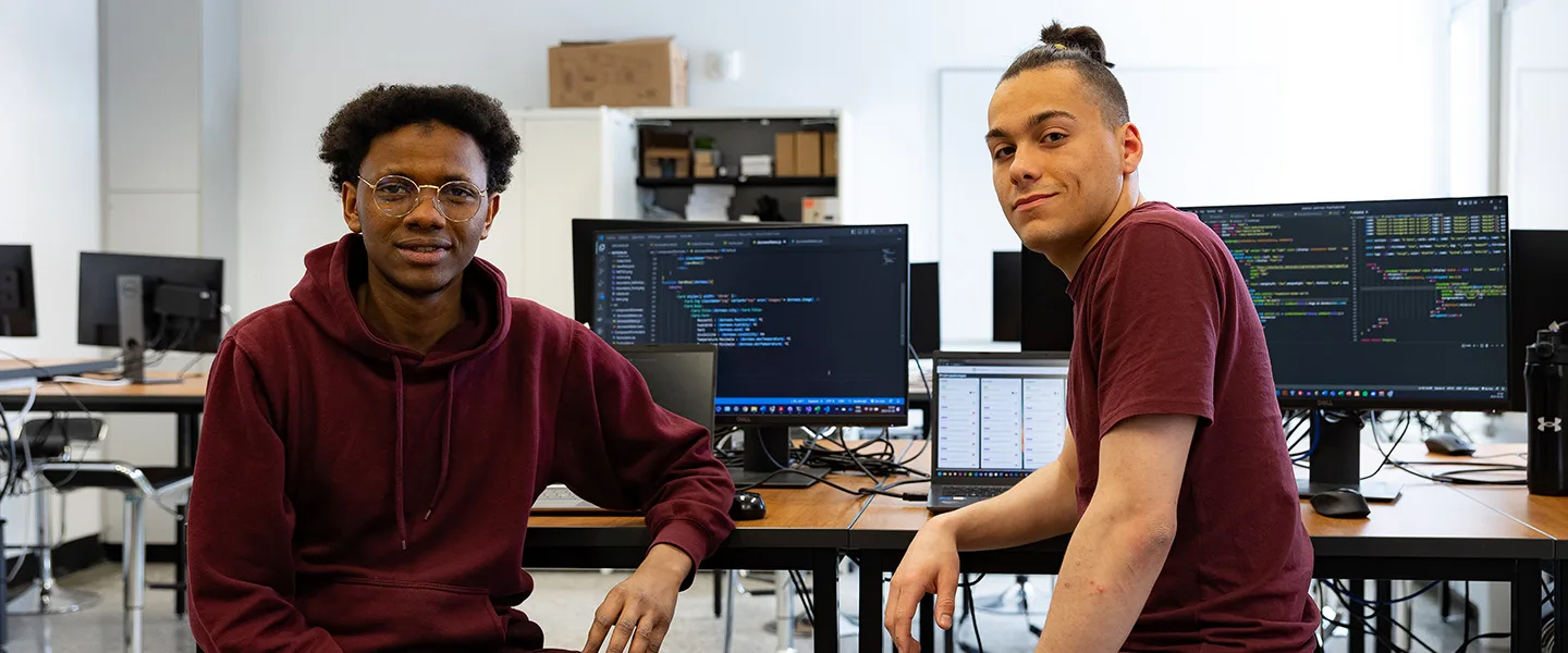 Deux étudiants devant des écrans d'ordinateur