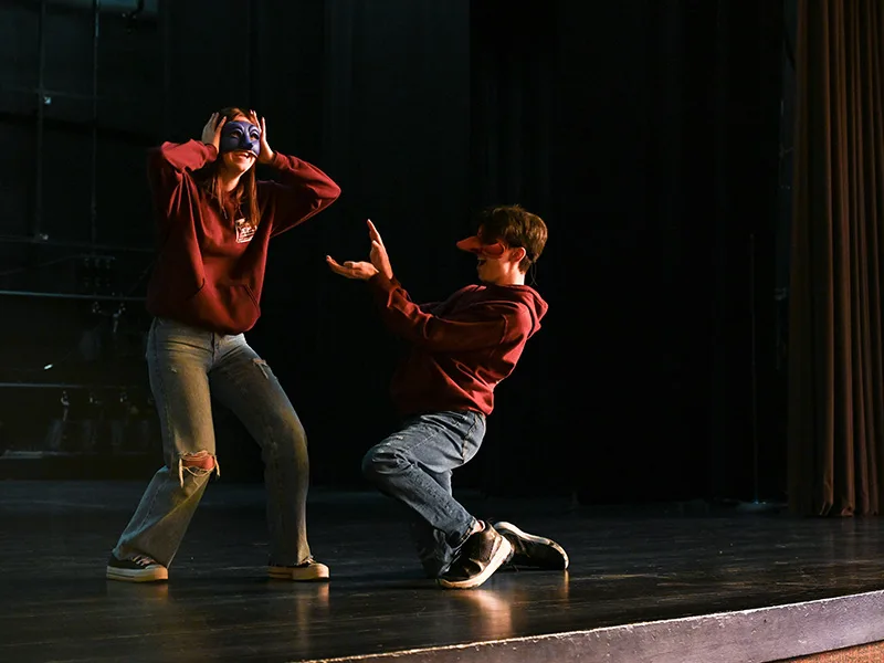 2 étudiants sur scène avec masque de la Comedia del arte
